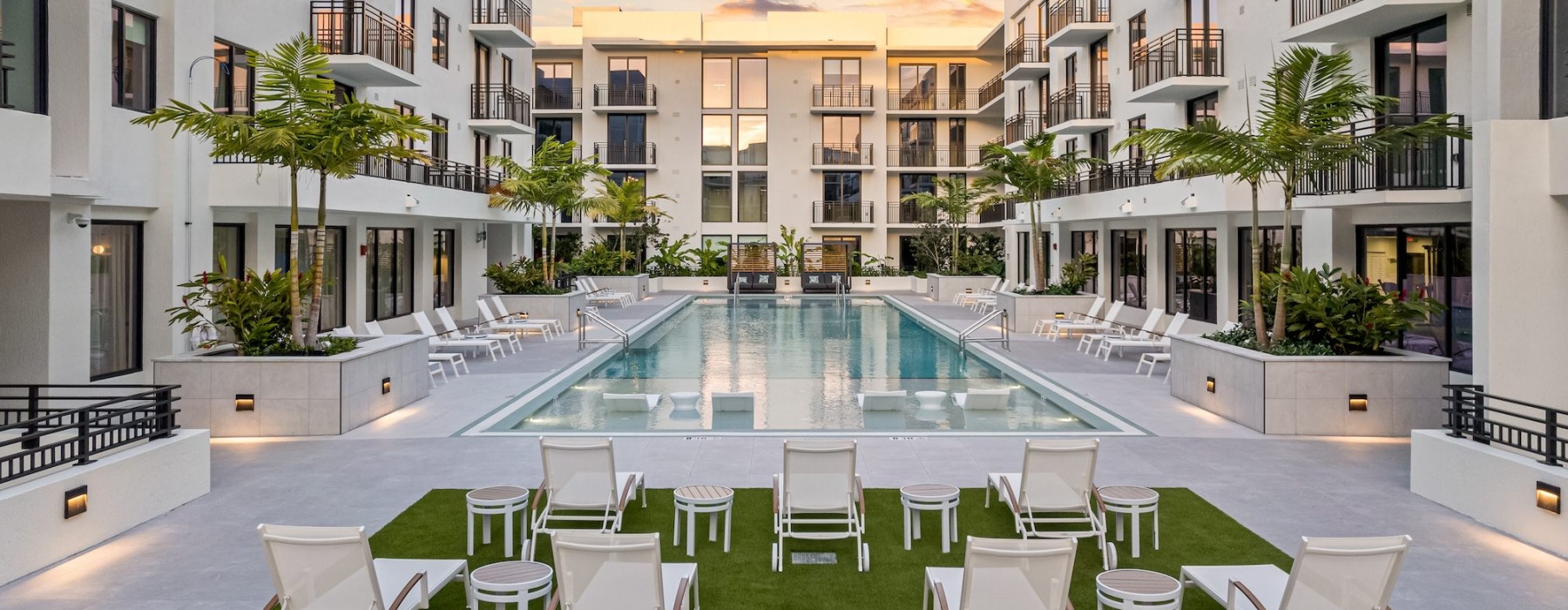 view of a pool in a courtyard with chairs