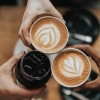 a group of people holding their coffee cups 